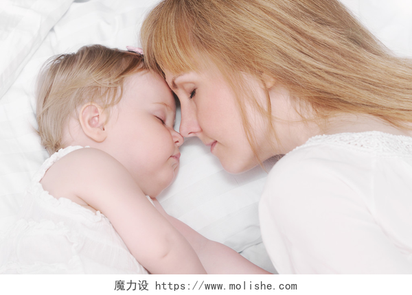 母亲和婴儿睡觉的特写小睡觉宝贝女孩用她充满爱心的母亲的肖像